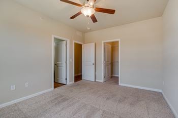 Carpeted Bedroom With Attached Bathroom & Walk-In Closet